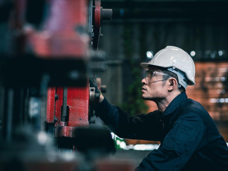 Man checking red industrial machine