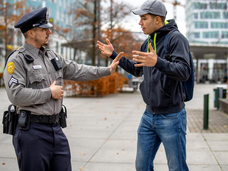 police officer calming an agitated man in an outdoor environment