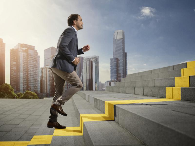 Person running up stairs, reaching new heights