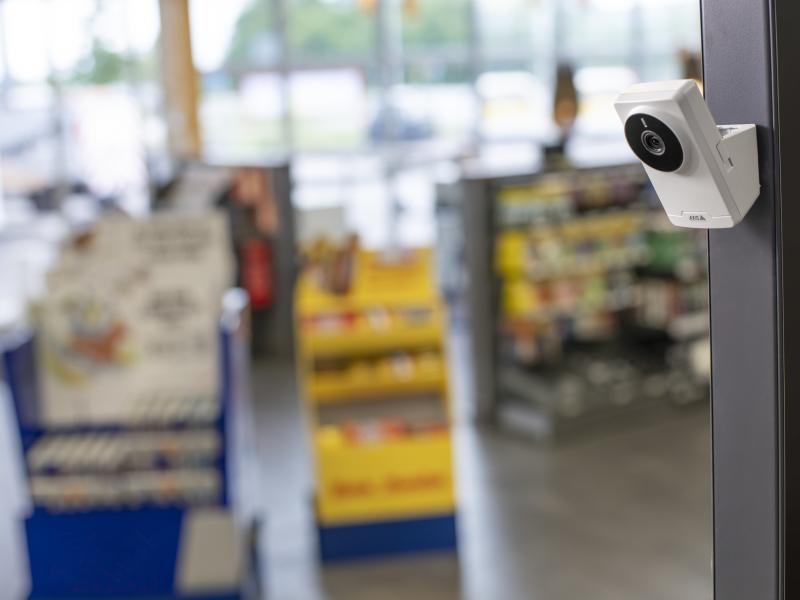 AXIS M1055-L Box Camera, mounted on a pole in a gas station store