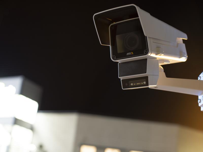 AXIS Q1656-DLE Radar-Video Fusion Camera, mounted outdoors. Dark sky in the background.