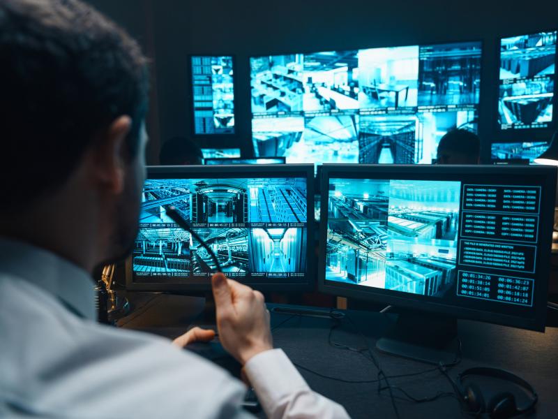 Person sitting in a monitor control room speaking into a microphone
