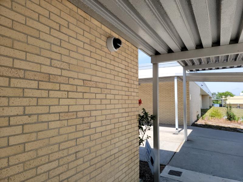 Panoramic dome camera on exterior wall with overhang