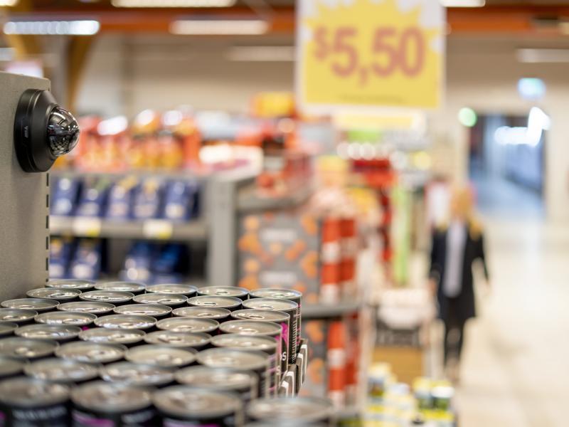 AXIS M4218-LV with black casing installed wall-mounted in grocery store