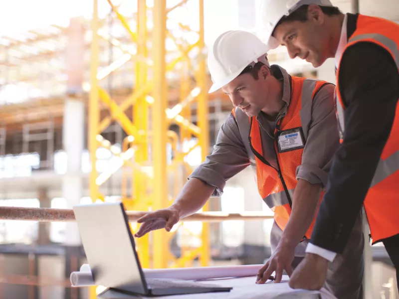 2men hardhats laptop
