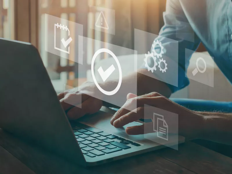 Hands on a laptop writing with symbols overlayed