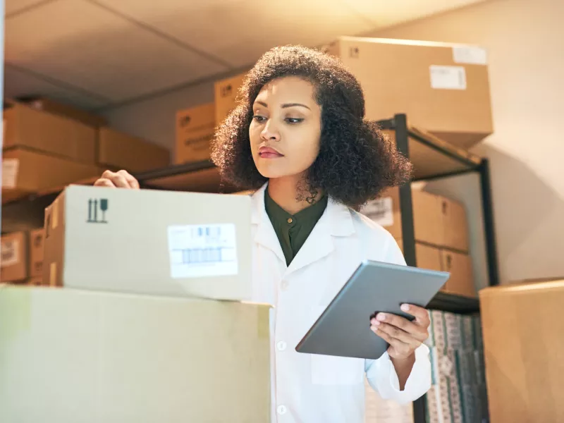 pharmacist woman tablet checkling stock boxes