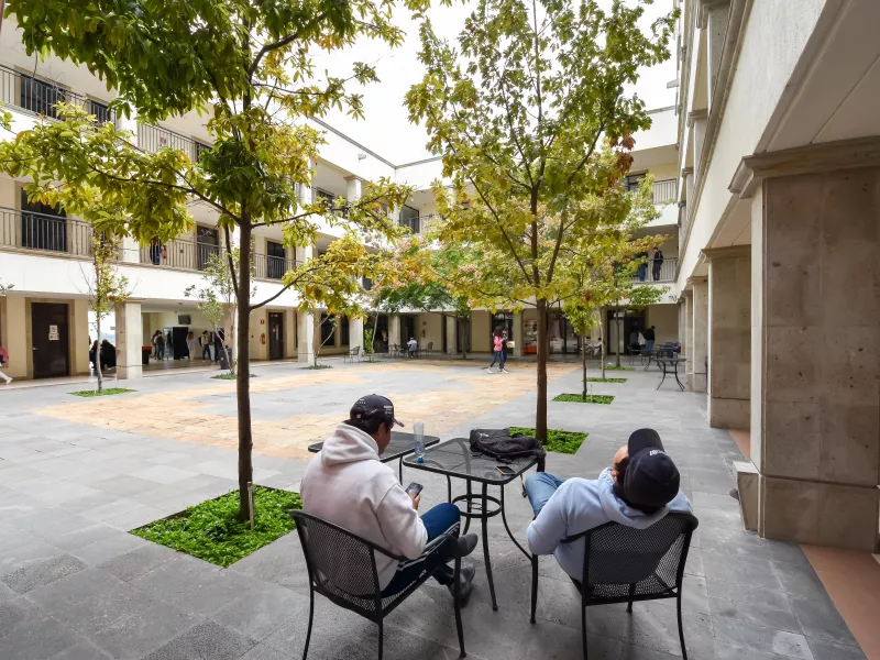 Courtyard of Anahuac University with students sitting at table