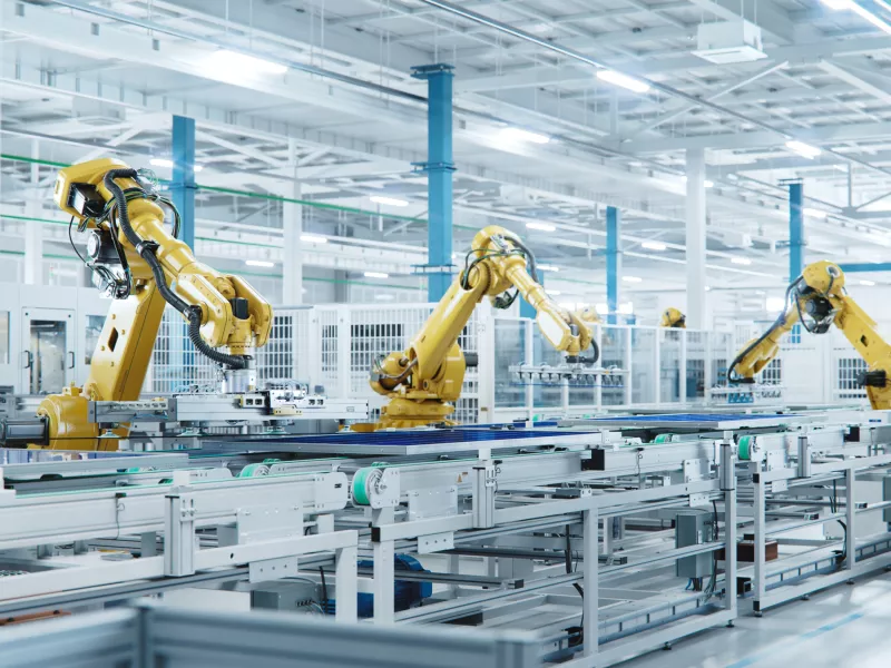 Yellow robots working on assembly lines with solar panels