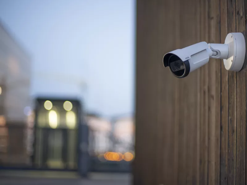 Bullet camera placed on a wooden wall 