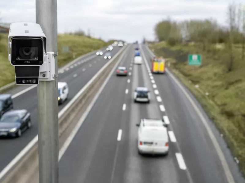 Camera to the left in the picture with highway and cars in the background