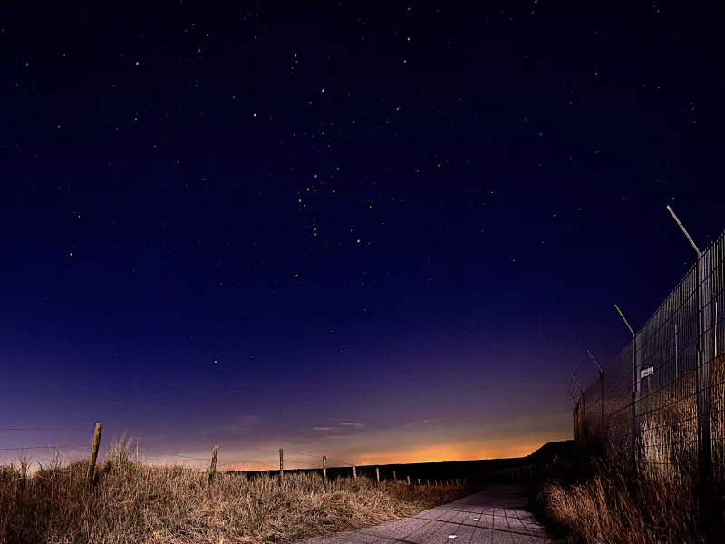 Path along a fence at night