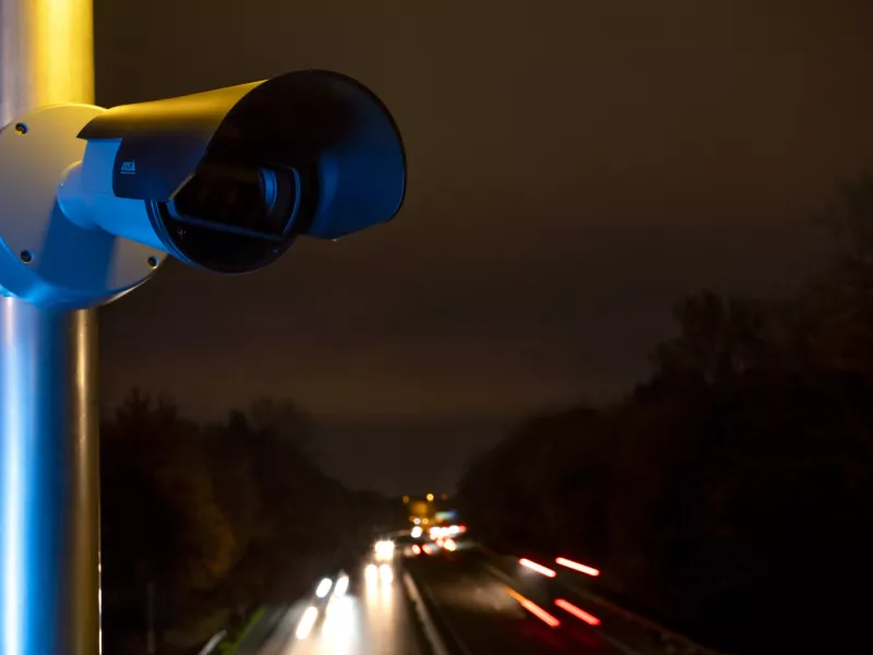 Camera mounted on pole overlooking highway at night