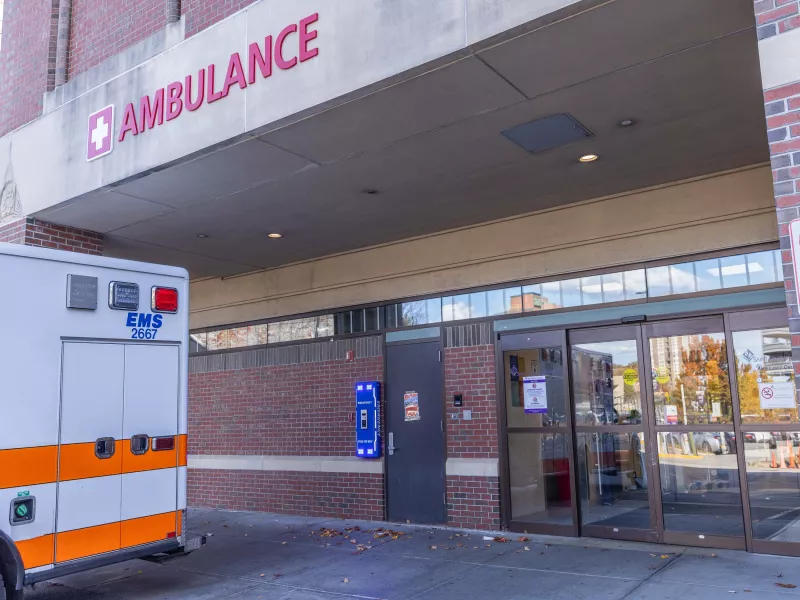 Back of ambulance in front of Emergency entrance at hospital with call box shown