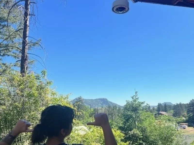 Shot of camera on roof overhang with worker in foreground