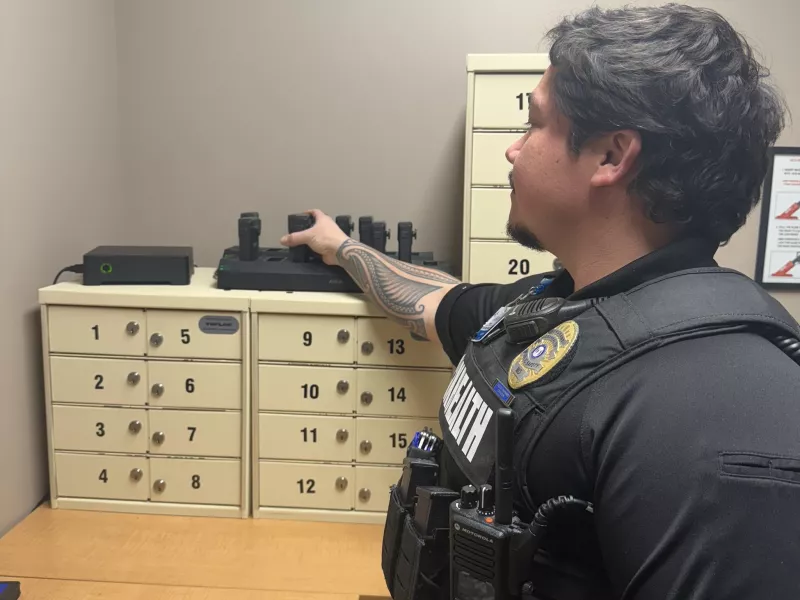 Security officer putting body camera in charging unit