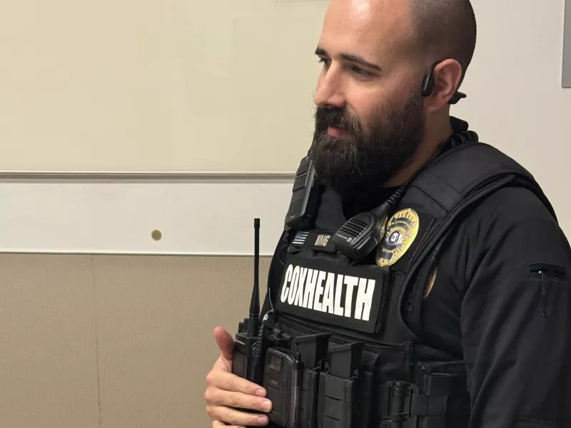 Security officer wearing body camera and depressing button