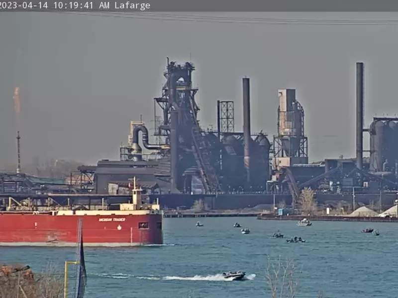 Shot of freight ship in river and smaller craft around it
