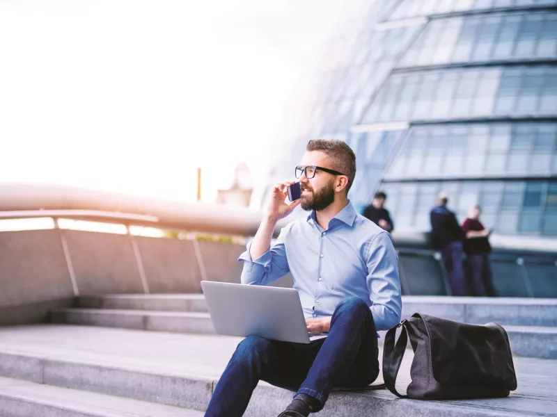 man sitting at stairs working remote