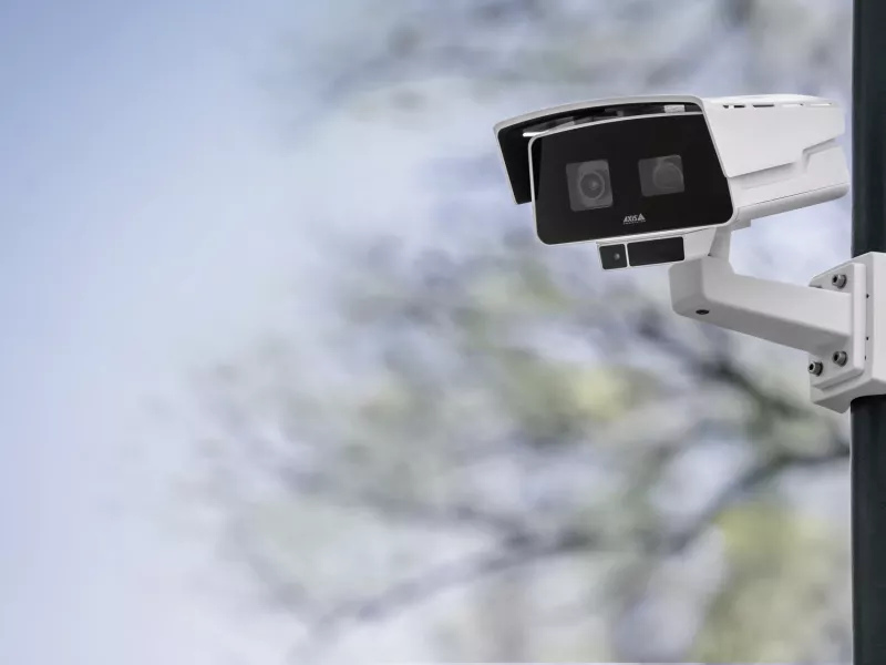 Camera mounted on pole with blurred building in the background