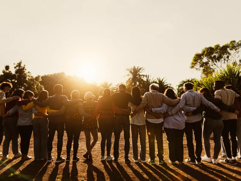 Image of people standing next to each other in a peaceful environment. 