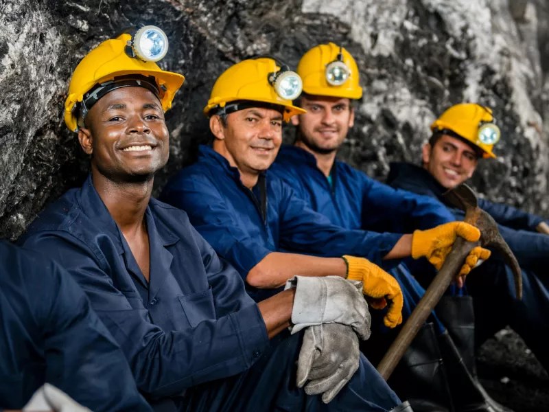 Happy miners in yellow hard hats