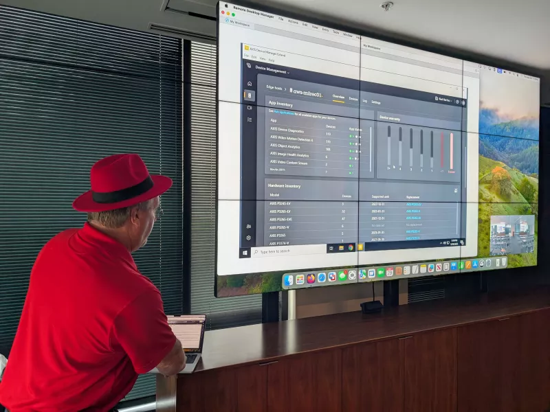 Red Hat IT person next to monitor of ADMx