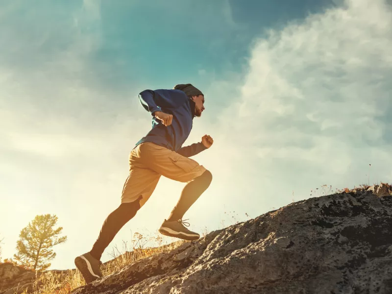 Man running uphill to showcase endurance