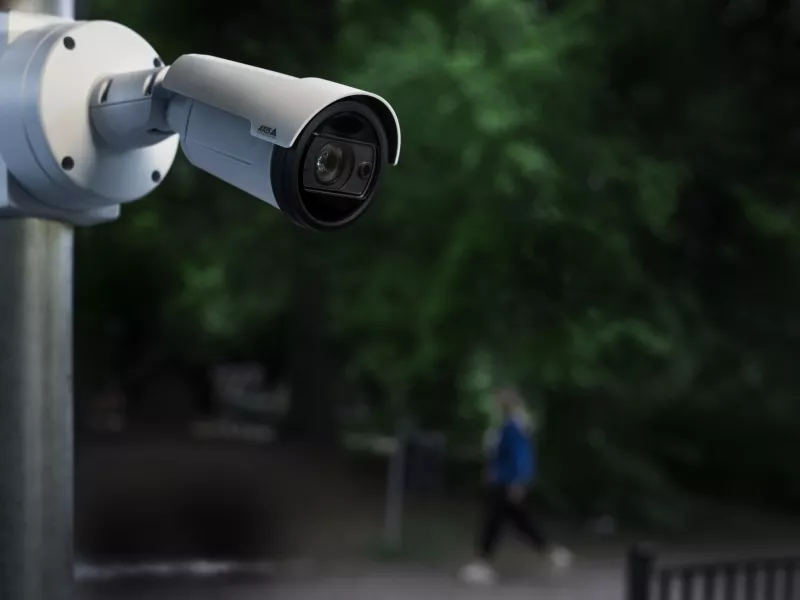 AXIS P1488-LE Bullet Camera mounted on a pole infront of a park during night