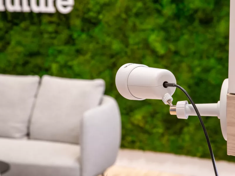 AXIS TF1804 mounted on wall with a grey couch in the backgrund