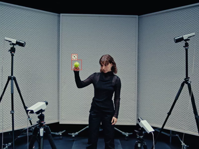 Woman holding up an object in front of Axis cameras with object detection.