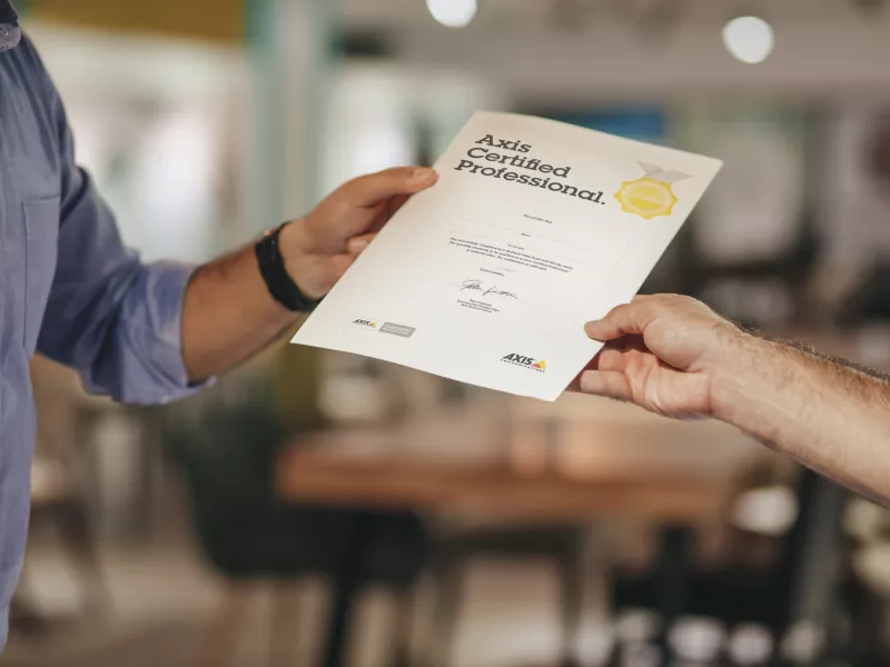 Man gets a certificate after passed the exam. He is now an Axis Certified Professional.