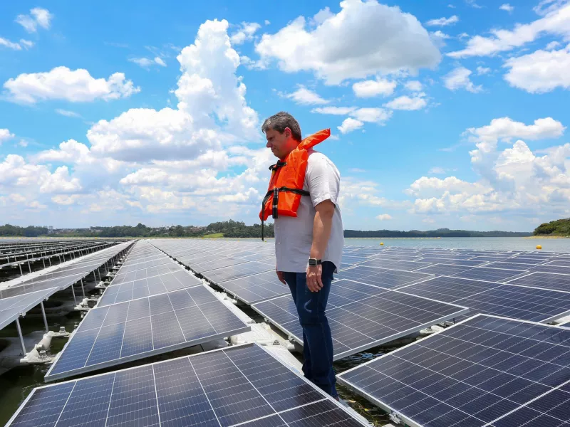 Man with orange life vest standing on floating solar farm