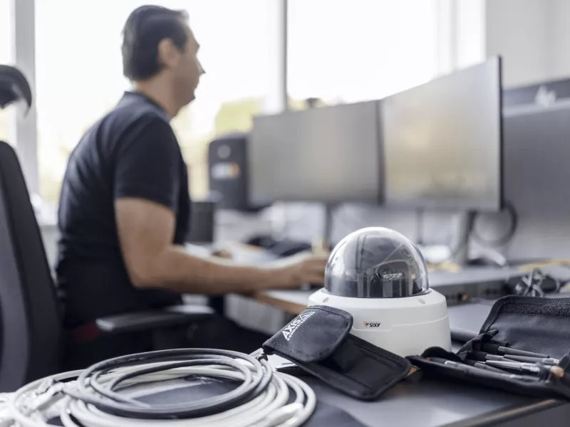 Person sitting by their desk with a camera in focus