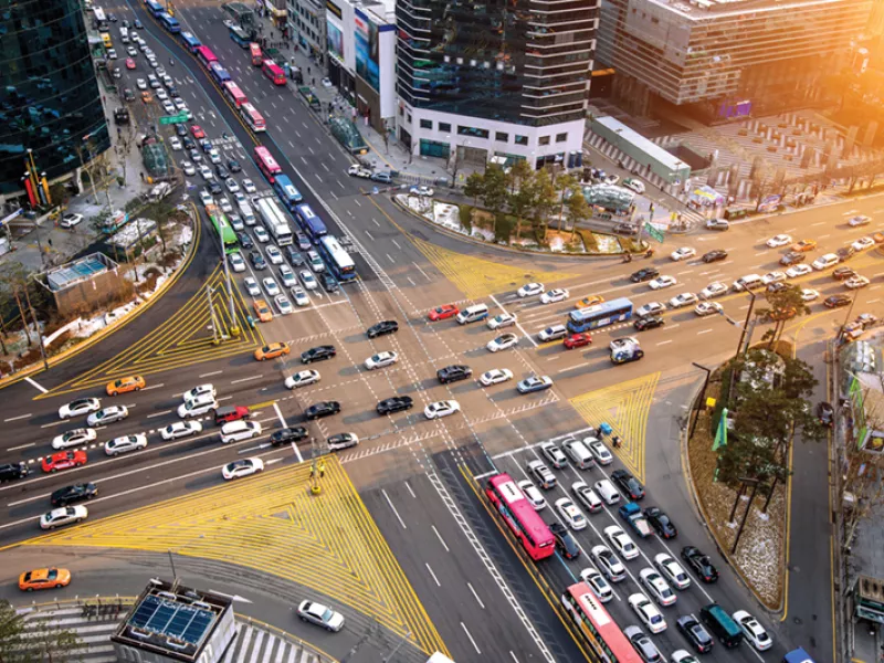 Smart traffic management at a busy urban intersection with cars, buses, cyclists, and pedestrians - showcasing the importance of intelligent traffic monitoring, intersection safety, and real-time video analytics for modern cities.