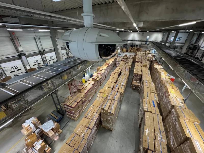 Two multisensor cameras, with a 180-degree angle of view, mounted on the ceiling brackets in a distribution center