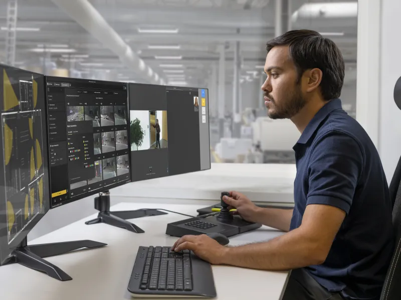 Man working with AXIS Camera Station Pro on three monitors