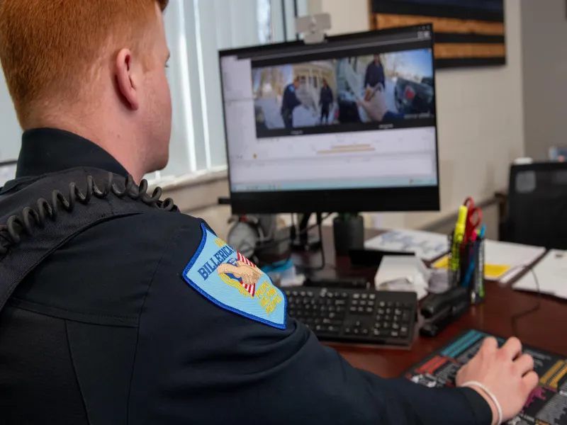 Officer at desk looking at monitor