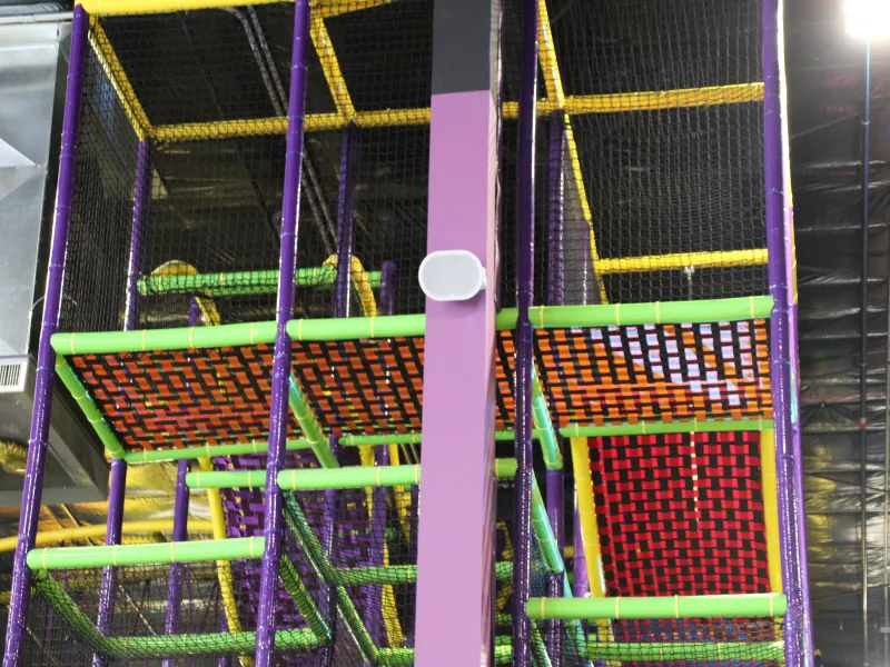 Column-mounted speaker with attractions in background