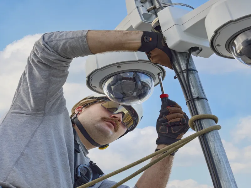 Technician works with camera on pole 
