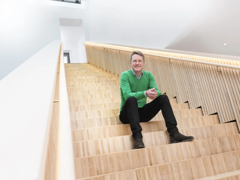 Anders Lyddby seduto sulle scale sorridendo alla telecamera