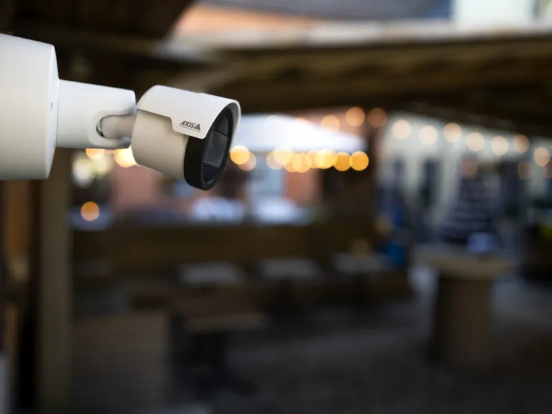 Bullet camera in white, mounted on wall in restaurant 