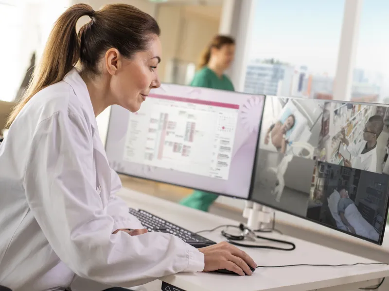 Healthcare professional looking at a computer remote patient monitoring
