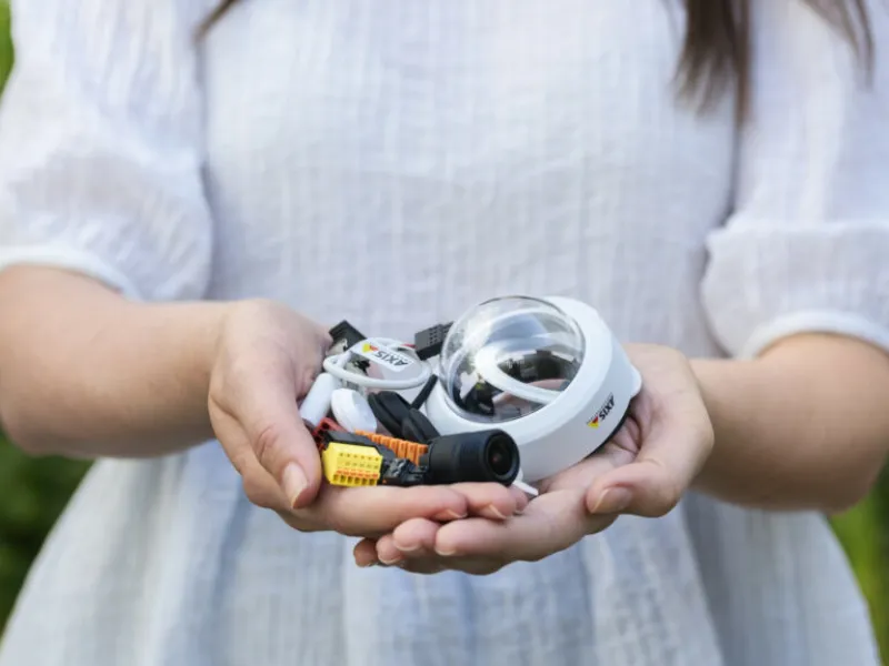 person holding camera parts