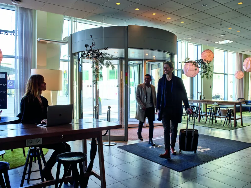 Guests entering a lobby past the reception desk