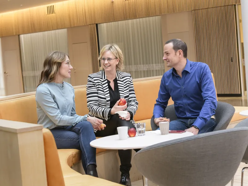 Three Axis colleagues sitting in an open-plan office area at the headquarters in Lund, having a chat.