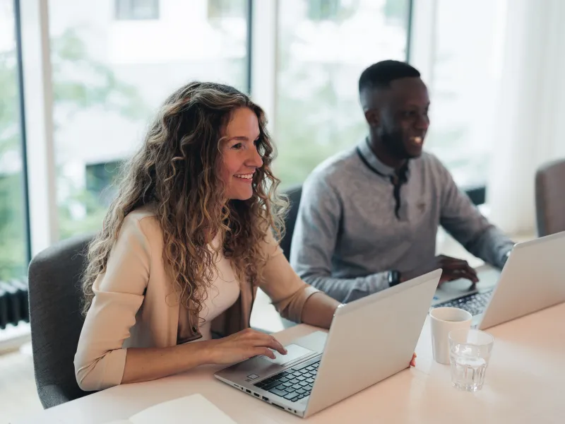 Two colleagues working on their laptops