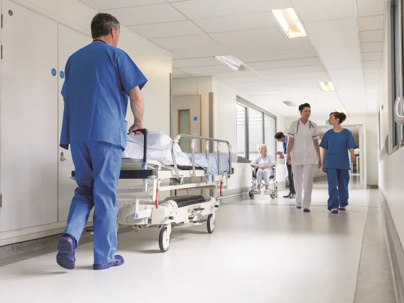 Hospital corridor with doctors and nurses walking past each other.