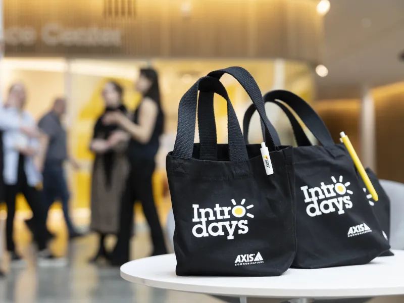 Axis Intro days goodie bags in the foreground. In the background, axis colleague standing outside Axis Experience Center. 