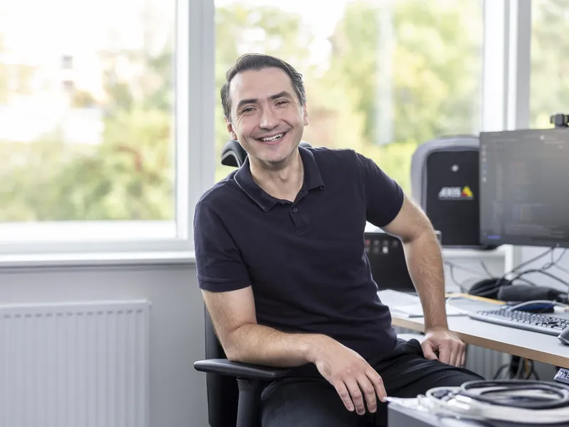 Axis employee smiling at their desk in the office.